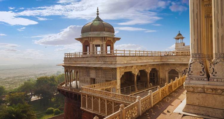 Balcón mogol ornamentado del Fuerte de Agra con vista a las llanuras del río Yamuna bajo la cálida luz de la tarde