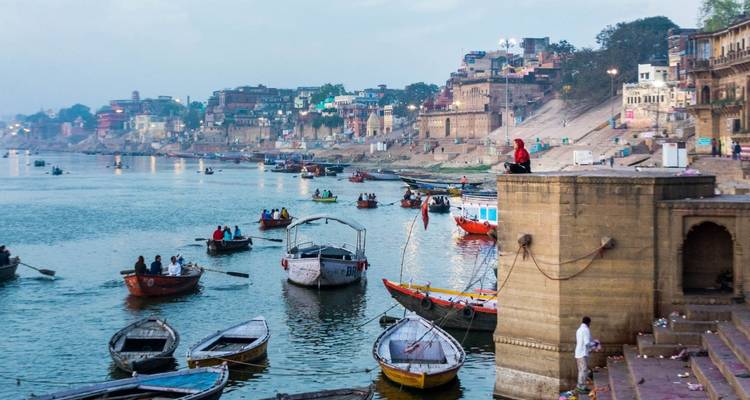 Morgendliche Szene am Ganges in Varanasi mit zahlreichen Holzbooten und Pilgern entlang der Ghats