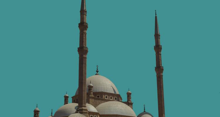 Silhouette der Kuppeln und Minarette der Muhammad-Ali-Moschee isoliert gegen einen blaugrünen Himmel.