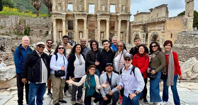 Un gran grupo de turistas posa alegremente ante la fachada de mármol de la Biblioteca de Celso en Éfeso.
