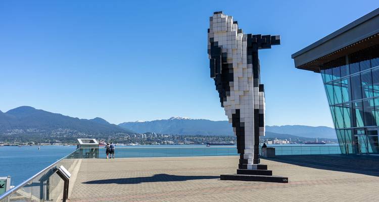 Gepixelde Digitale Orca sculptuur kijkt uit over Burrard Inlet met kustbergen op de achtergrond.