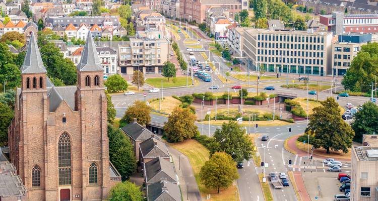 Vista aérea urbana que presenta una iglesia de torres gemelas y carreteras modernas serpenteando por Arnhem