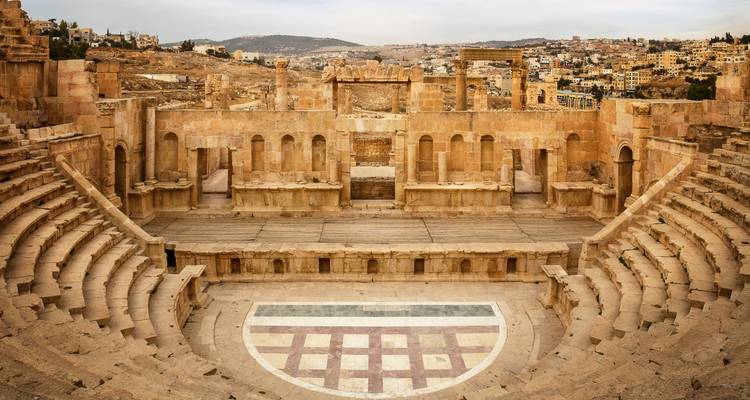 Panoramic view of the ancient stone theatre at Jerash with town visible beyond