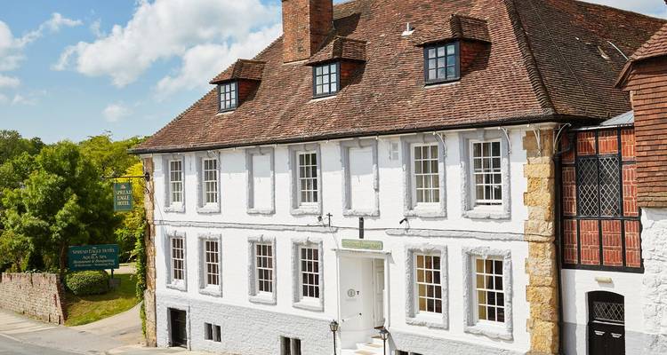 Extérieur de l'historique Spread Eagle Hotel blanc avec ses fenêtres à meneaux et son toit de tuiles.