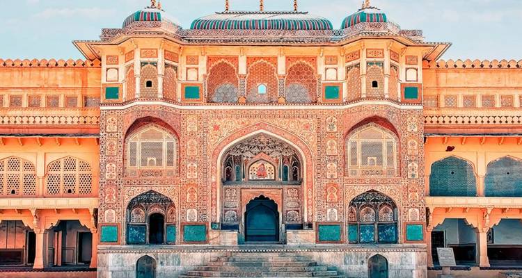 Ornamental bemalte Fassade und gewölbter Torbogen des Stadtpalastes von Jaipur, reich verziert mit Mosaiken.