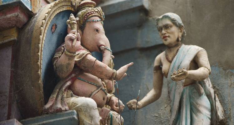 Nahaufnahme von Ganesha und Begleiterfigur-Skulptur an einer südindischen Tempelwand.