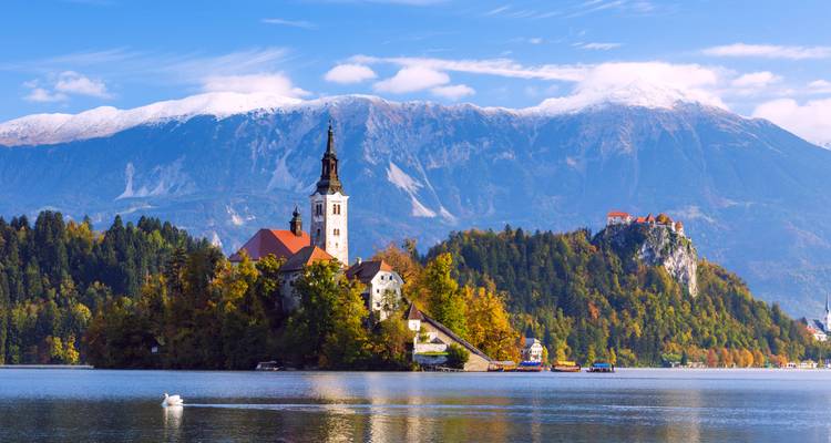 L'église féerique de l'Assomption se dresse sur l'île du lac de Bled avec les Alpes juliennes enneigées en arrière-plan.