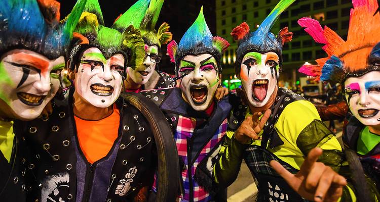 Levendig gekostumeerde artiesten met geschminkte gezichten vieren tijdens het levendige carnaval van Uruguay 's nachts.