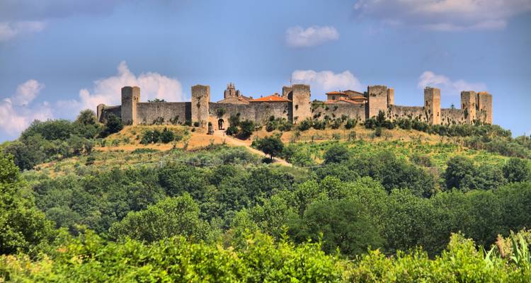 Fortaleza medieval amurallada de Monteriggioni situada en la cima de una colina verde.