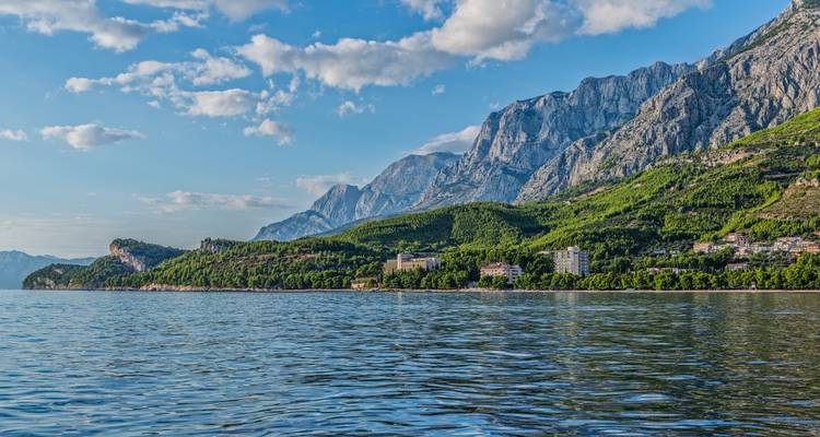Vista panorámica de la Riviera de Makarska con laderas cubiertas de pinos, imponentes montañas kársticas y las tranquilas aguas del Adriático.