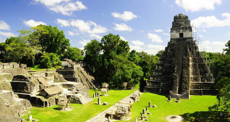 Antiguos templos mayas se alzan sobre el dosel de la selva bajo un cielo azul brillante en Tikal.