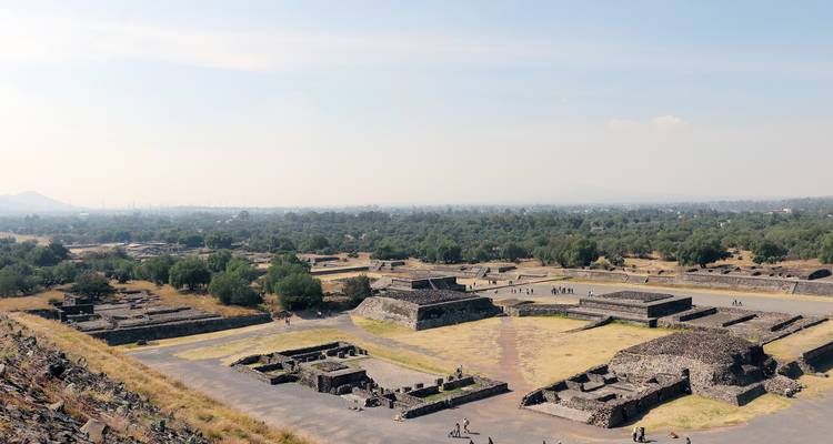 Vue aérienne large des places anciennes, temples et pyramides de Teotihuacán s'étendant à travers la plaine.
