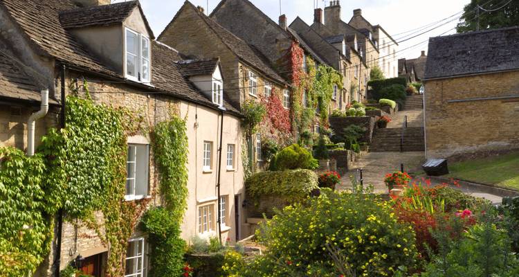 De charmantes maisons en pierre couvertes de vignes et de fleurs bordent une ruelle étroite du village.