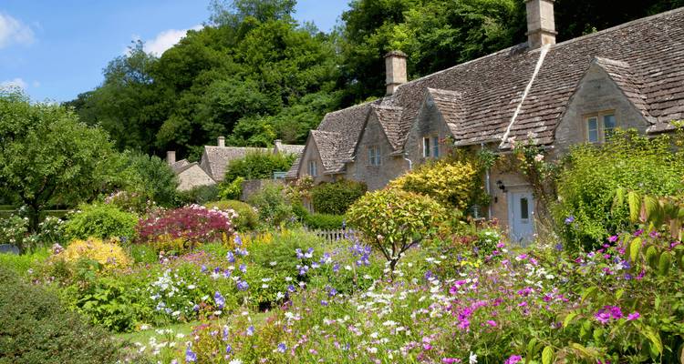 Des chaumières pittoresques en pierre encadrées par de vibrants jardins de cottage débordant de fleurs d'été.