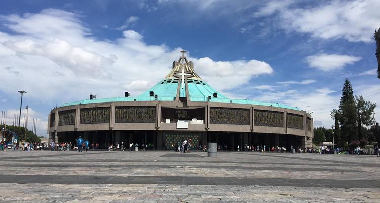 Basilique moderne de Notre-Dame de Guadalupe avec un toit en dôme turquoise sur une place animée de Mexico.