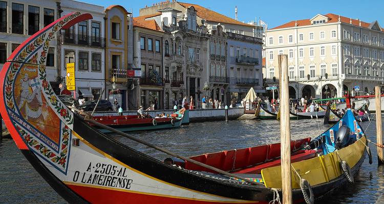 Embarcaciones moliceiro tradicionales con proas coloridas atracadas a lo largo del pintoresco canal en Aveiro.