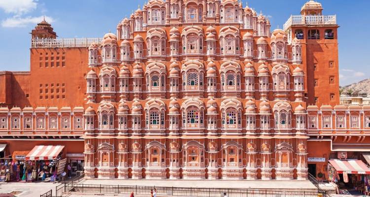 Die kunstvolle rosafarbene Fassade von Jaipurs Hawa Mahal, die sich unter einem klaren blauen Himmel erhebt.