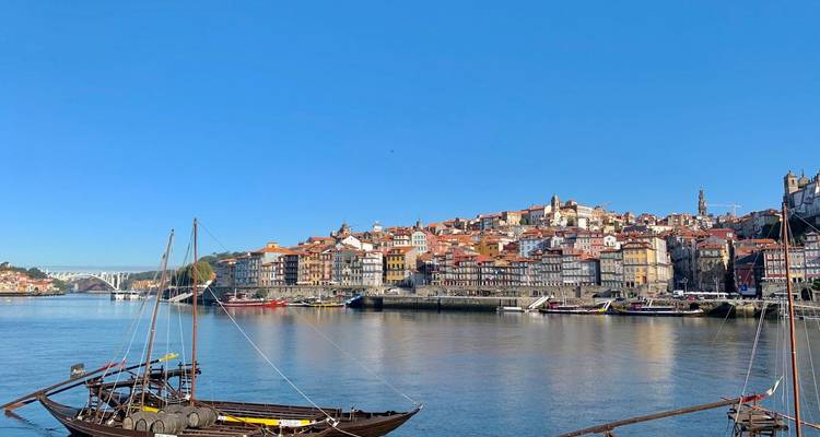 Historische Flusslandschaft mit bunten Häusern von Porto und traditionellen Rabelo-Booten auf dem Douro.