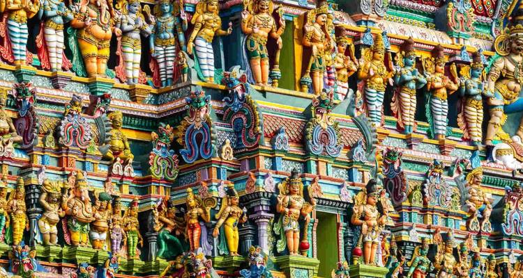 Leuchtend bemalte Gottheiten bedecken die kunstvolle Fassade eines südindischen Gopuram-Turms.