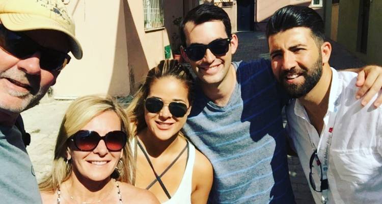 Selfie de groupe de voyageurs souriants dans une rue ensoleillée