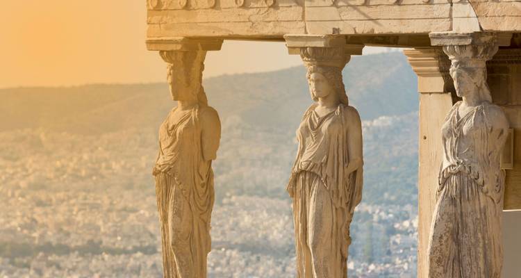 Gros plan des statues des Cariatides de l'Érechthéion sur l'Acropole contemplant Athènes dans la chaude lumière du coucher de soleil.