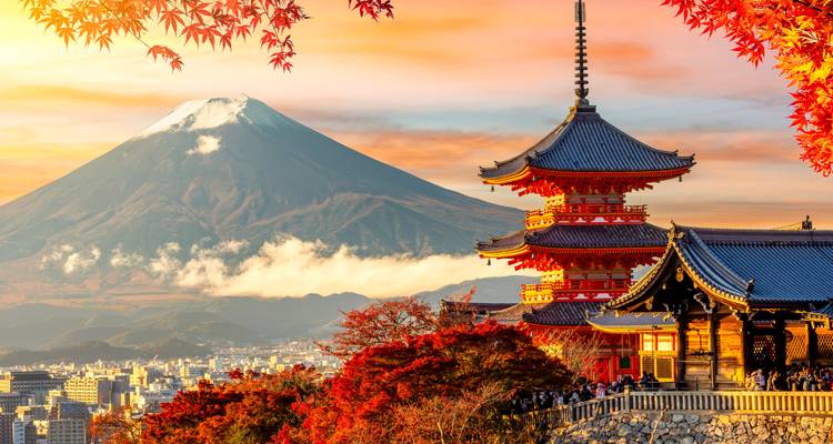 Ikonischer Blick auf den Mount Fuji, der hinter der Chureito-Pagoda aufsteigt, eingerahmt von leuchtenden Herbstblättern bei Sonnenuntergang.