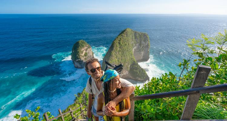 Couple heureux s'embrassant au point de vue de Kelingking surplombant les falaises turquoise de l'océan