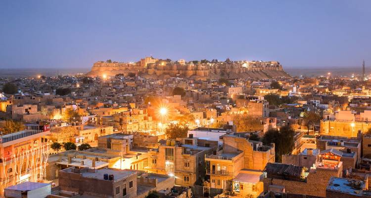 Dämmerungspanorama der beleuchteten Festung Jaisalmer über der goldenen Stadtlandschaft