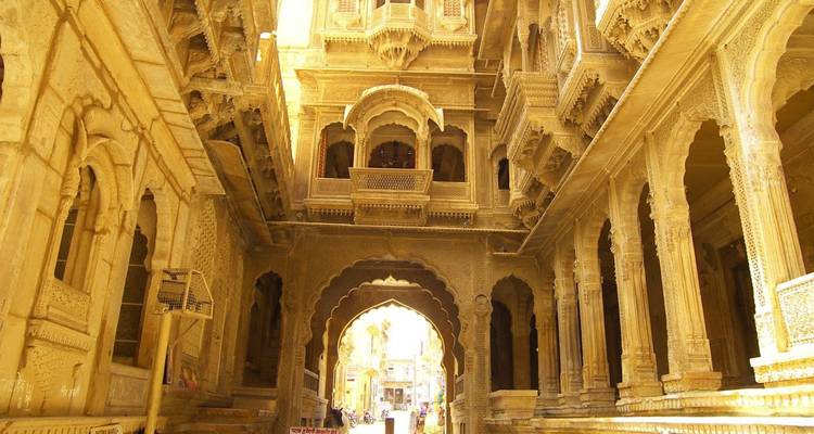 Goldener Sandstein-Haveli-Korridor in warmem Licht gebadet mit kunstvollen Balkonen