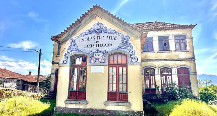 Ein altes portugiesisches Schulhaus mit kunstvollen blauen Azulejo-Kacheln steht unter hellem Sonnenschein