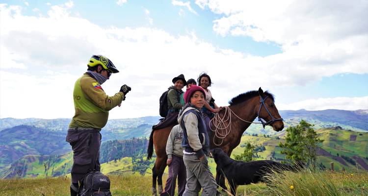 Mountainbiker, der Fotos von einer indigenen Familie zu Pferd mit einem Hund auf einem Hochplateau macht