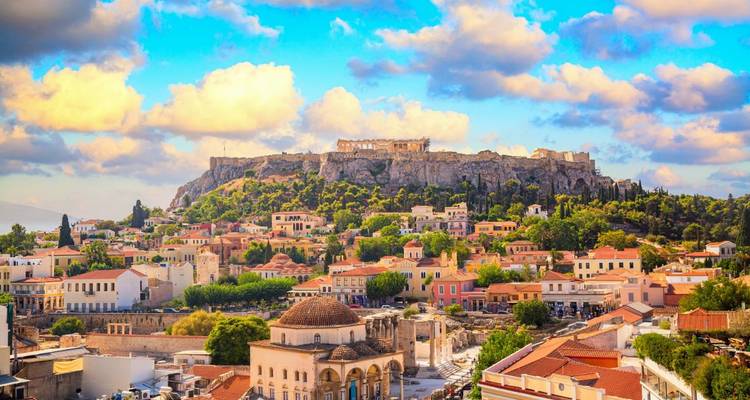 Zonovergoten panorama van Athene met de Akropolisheuvel die de kleurrijke stadswijken bekroont onder pluizige wolken.