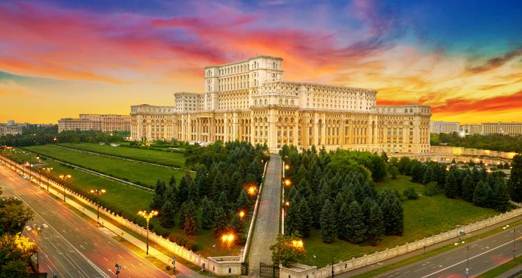 Parlamentspalast in Bukarest beleuchtet bei Sonnenuntergang mit lebhaftem Himmel