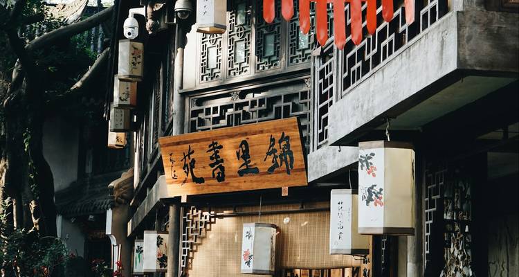 Traditional wooden storefront with Chinese calligraphy signs and hanging lanterns in soft light.
