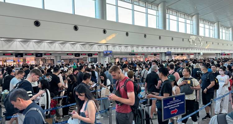 Packed immigration hall with dense queues of passengers stretching across the terminal.