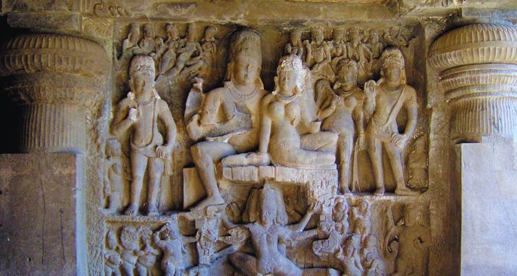 Oud in rots uitgehouwen reliëf met hindoe-goden in een schemering verlichte grotverfleier