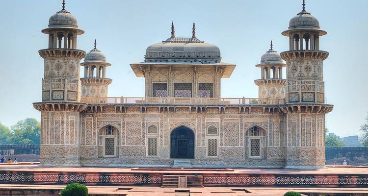 Het sierlijke marmeren mausoleum van Itimad-ud-Daulah, de "Baby Taj", staat symmetrisch tegen een bleke hemel.