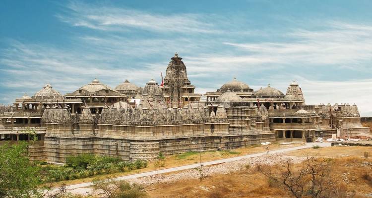 Vue expansive des dômes et flèches de marbre finement sculptés du temple jaïn de Ranakpur sous un ciel bleu.