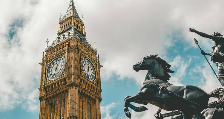 Close-up van Big Ben klokkentoren naast bronzen Boudicca standbeeld onder wolken