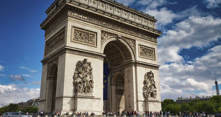 Majestueuze Arc de Triomphe torenhoog boven bezoekers onder gedeeltelijk bewolkte hemel