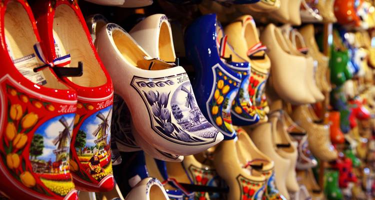 Muurdisplay van kleurrijk beschilderde Nederlandse houten klompen in een souvenirwinkel