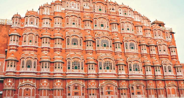 Vue rapprochée de la façade rose complexe et des fenêtres à treillis du Hawa Mahal de Jaipur.