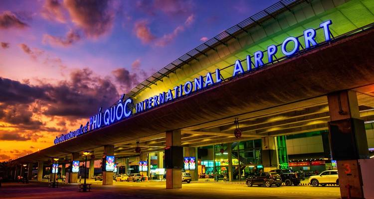 Phu Quoc International Airport terminal glowing under a dramatic purple-orange sunset sky.