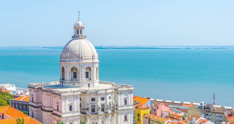 Cúpula blanca del Panteón Nacional de Lisboa que se eleva sobre los coloridos tejados de Alfama junto al río Tajo