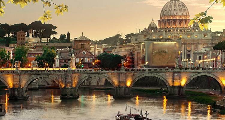 Resplandor crepuscular sobre la Basílica de San Pedro y los arcos iluminados del Ponte Sant'Angelo sobre el Tíber.
