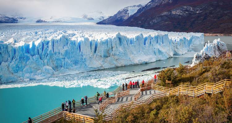 Plateformes d'observation en bois remplies de visiteurs surplombant le glacier Perito Moreno d'un bleu éclatant.