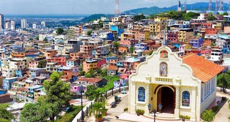 Barrio colorido en la ladera con casas de colores pastel y una pequeña capilla blanca en la cima que domina Guayaquil