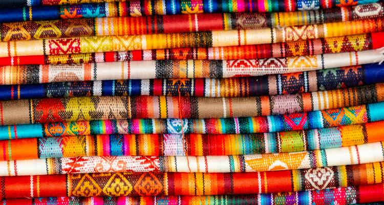 Gros plan de textiles tissés aux couleurs vives empilés en couches ordonnées