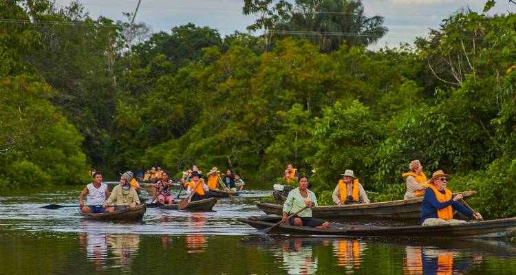 De nombreux canoës remplis de voyageurs en gilets de sauvetage pagaient à travers les voies navigables calmes de la forêt tropicale.