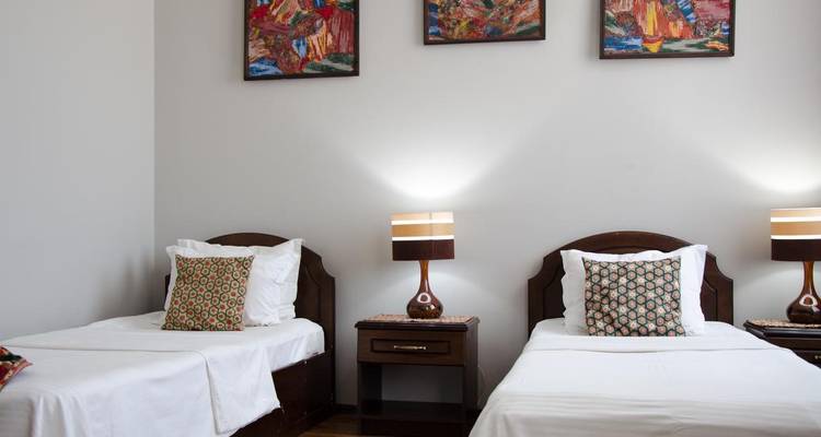 Twin-bed hotel room with minimalist decor (duplicate).